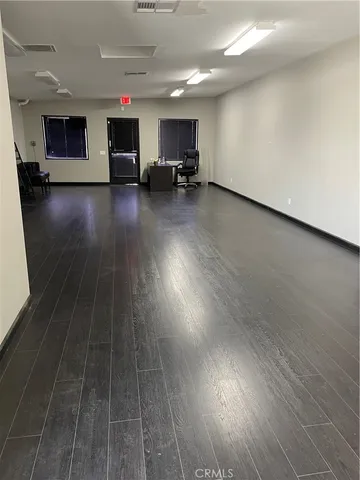an empty room with wooden floor and a fireplace