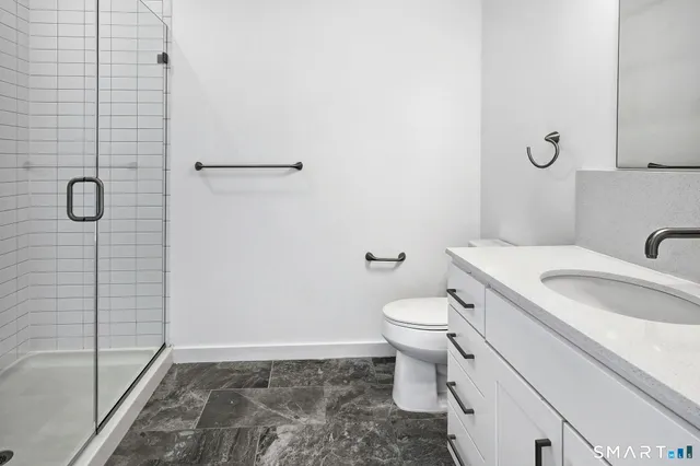 a bedroom with a bed and large windows