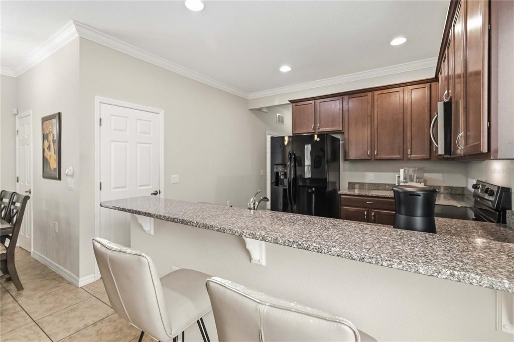 3430 Schoolhouse Road Harmony, FL 34773 - Photo 12 of 70 a kitchen with stainless steel appliances granite countertop a refrigerator sink and stove