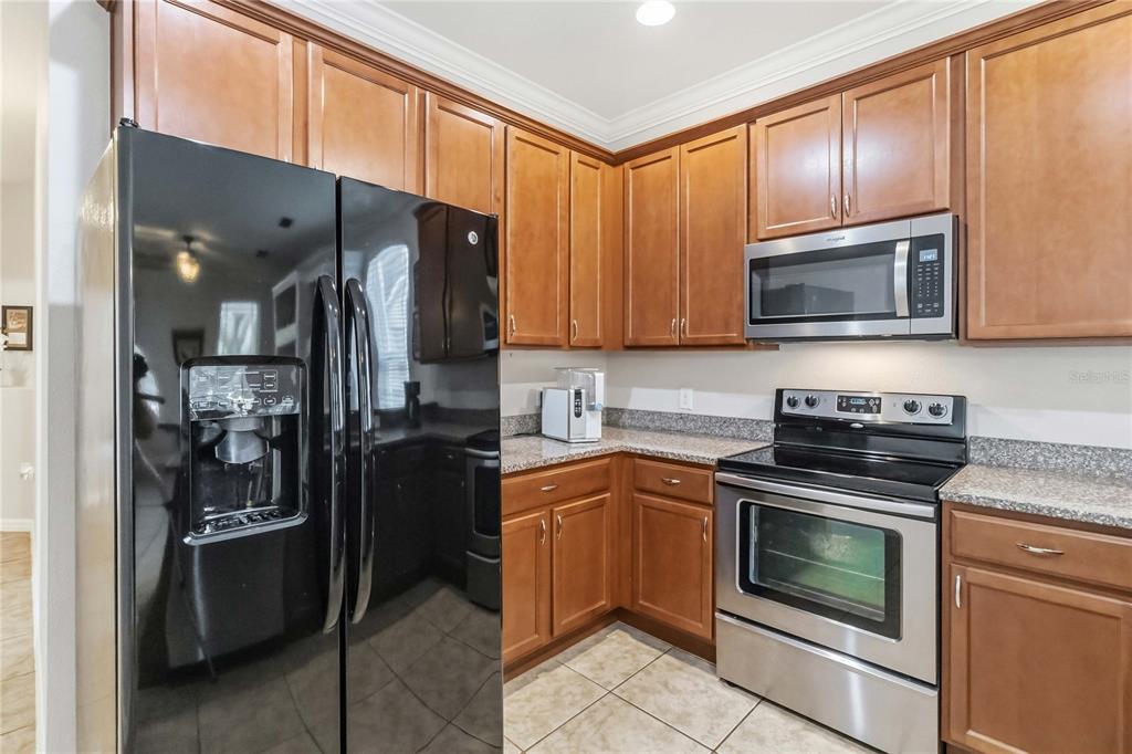 3430 Schoolhouse Road Harmony, FL 34773 - Photo 14 of 70 a kitchen with a refrigerator stove and microwave