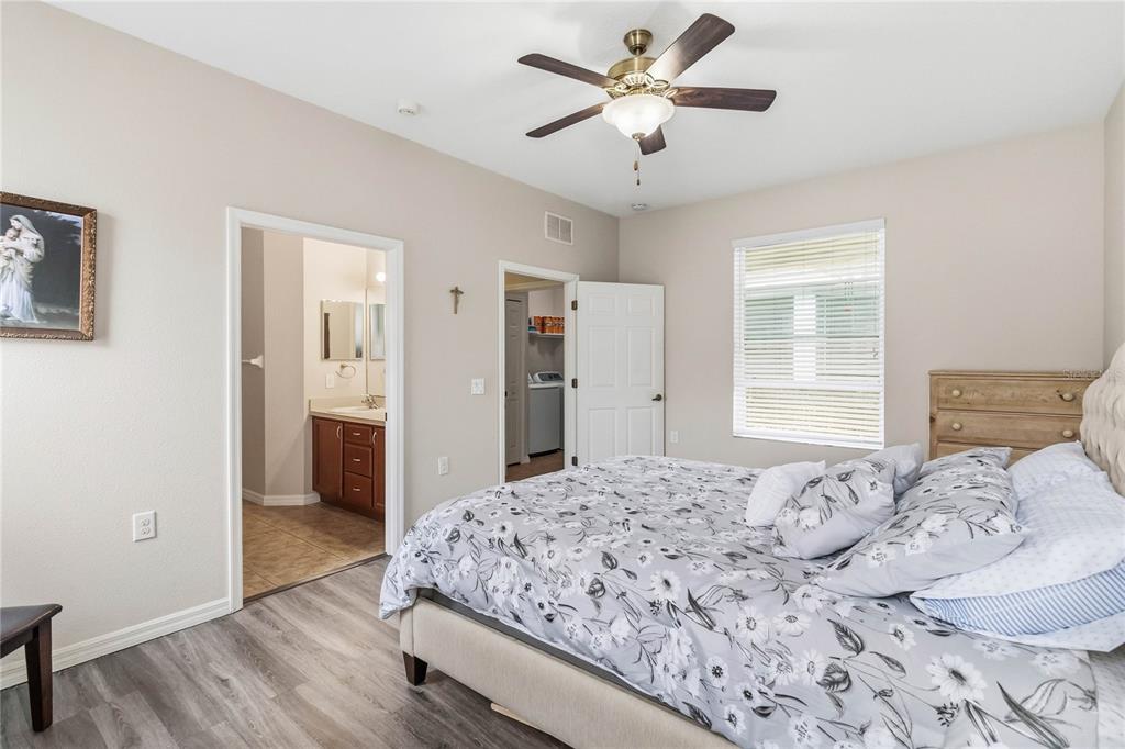 3430 Schoolhouse Road Harmony, FL 34773 - Photo 16 of 70 a bedroom with a large bed and a chandelier