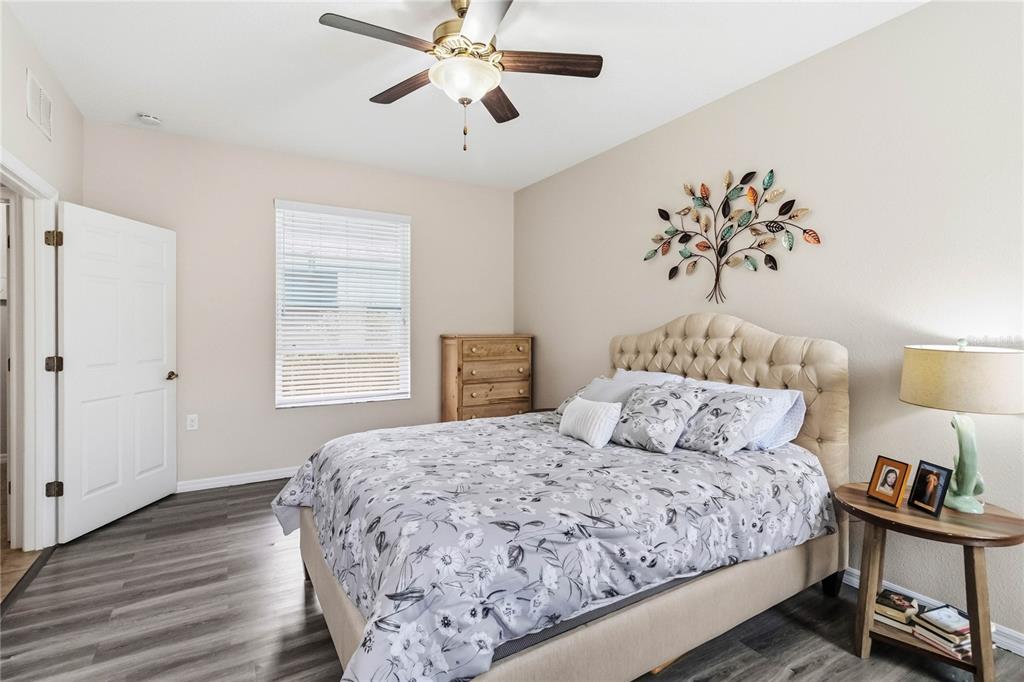 3430 Schoolhouse Road Harmony, FL 34773 - Photo 18 of 70 a bedroom with a large bed and a chandelier