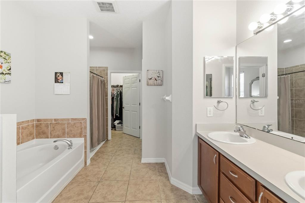 3430 Schoolhouse Road Harmony, FL 34773 - Photo 21 of 70 a bathroom with a tub sink shower and two mirror