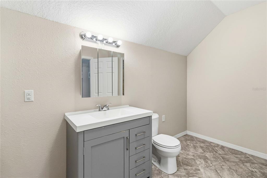 3430 Schoolhouse Road Harmony, FL 34773 - Photo 35 of 70 a bathroom with a sink a toilet and mirror