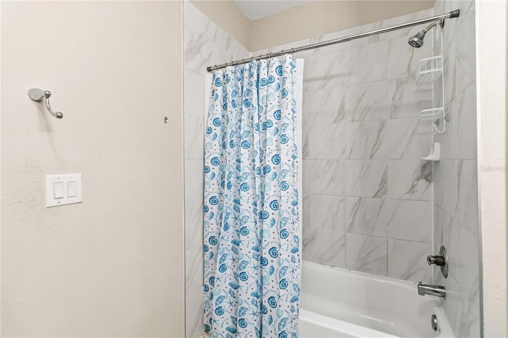 3430 Schoolhouse Road Harmony, FL 34773 - Photo 36 of 70 a bathroom with a shower curtain and a shower curtain
