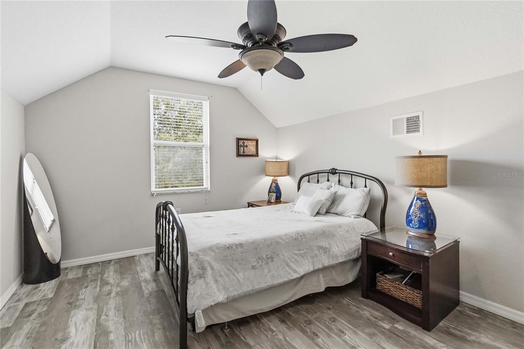 3430 Schoolhouse Road Harmony, FL 34773 - Photo 40 of 70 a bedroom with a bed a window and a chandelier