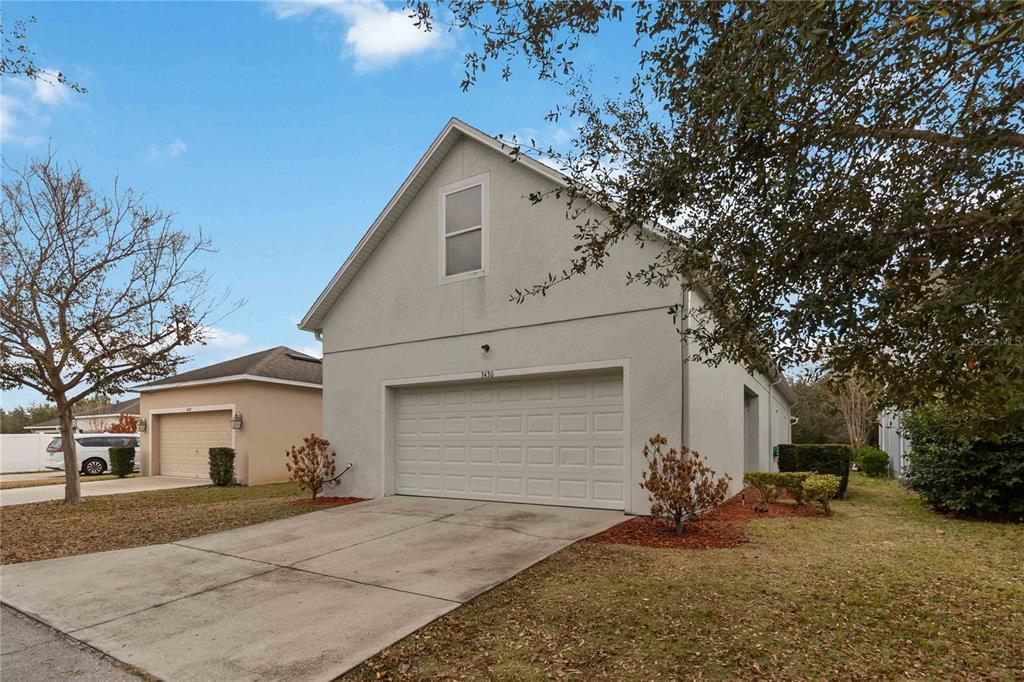3430 Schoolhouse Road Harmony, FL 34773 - Photo 43 of 70 a view of a white house with a large tree and yard