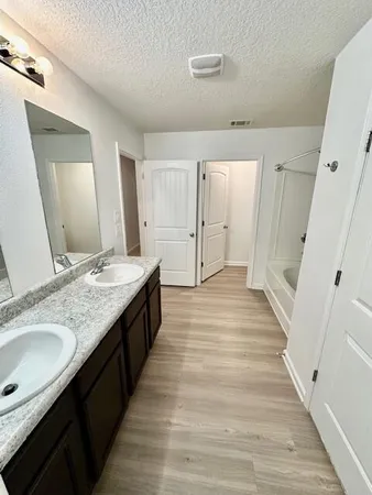 a bathroom with a tub sink and mirror