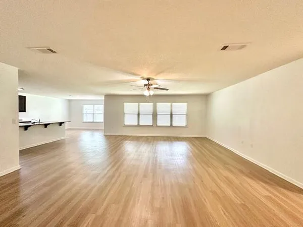 a view of a livingroom with wooden floor and a ceiling fan