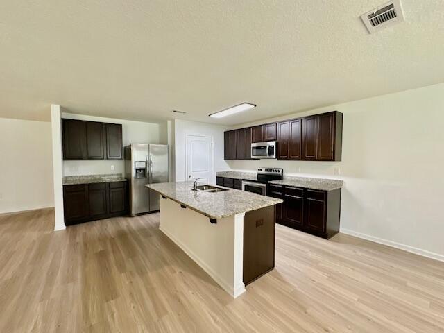 348 Merlin Court Crestview, FL 32539 - Photo 7 of 40 a large kitchen with stainless steel appliances granite countertop a stove a sink dishwasher and a refrigerator with wooden floor