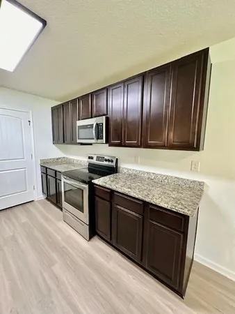 a kitchen with stainless steel appliances granite countertop a stove a sink and a refrigerator