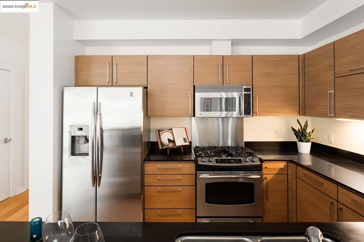 200 2nd Street, Unit 215 Oakland, CA 94607 - Photo 5 of 18 a kitchen with stainless steel appliances granite countertop a refrigerator and a stove