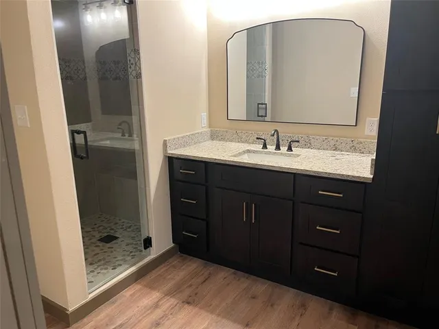 a bathroom with a sink a mirror and shower