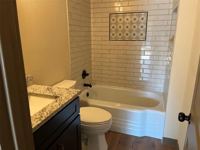 a bathroom with a granite countertop sink toilet and shower