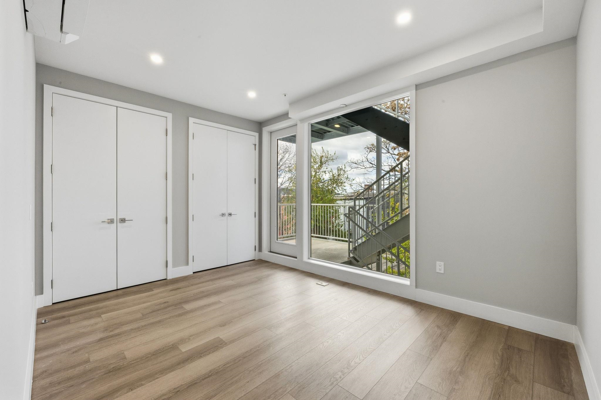 77 Van Reypen Street, Unit 4 Jersey City, NJ 07306 - Photo 7 of 23 a view of an empty room with wooden floor and a window