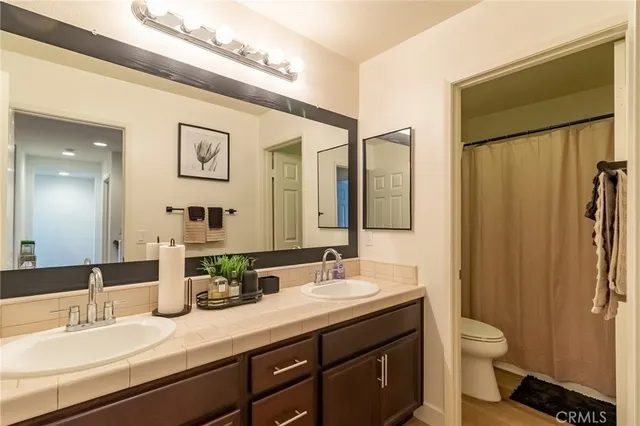 a bathroom with a granite countertop sink toilet and shower