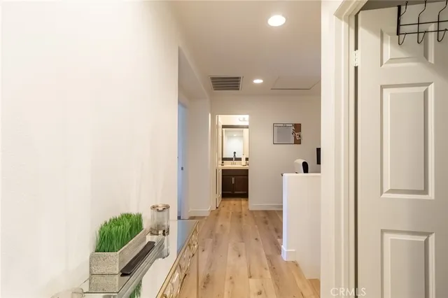 a view of a hallway with wooden floor and a living room