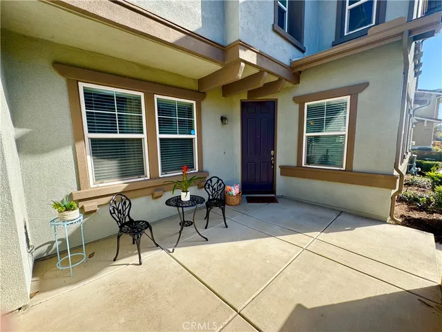 a view of a house with chairs and table in a patio