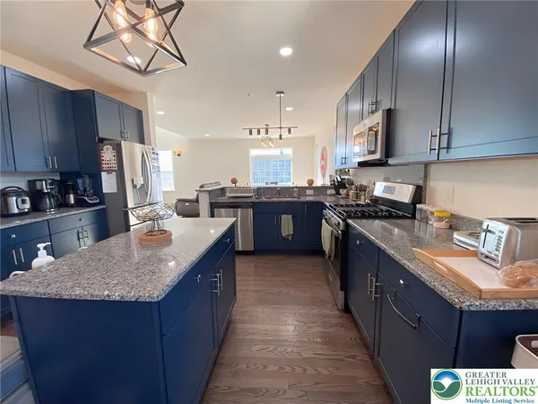 a kitchen with stainless steel appliances granite countertop a sink a stove and a refrigerator