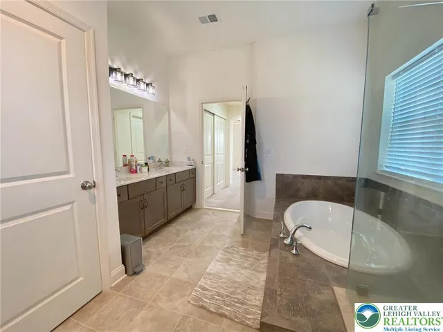 a bathroom with a tub sink and mirror