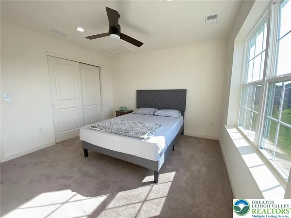 a bedroom with a bed and a large window