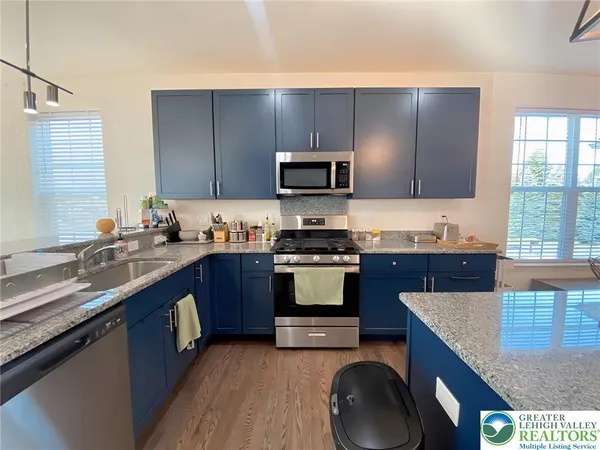 a kitchen with granite countertop a stove a sink and a microwave