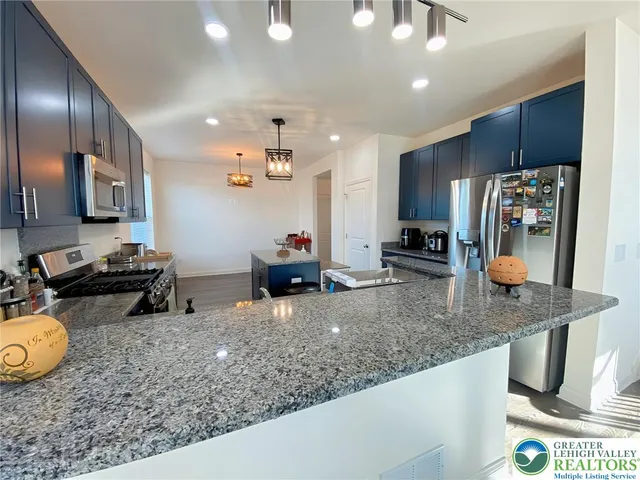 a kitchen with stainless steel appliances granite countertop a sink a stove and a refrigerator