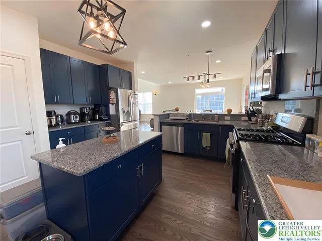 a large kitchen with stainless steel appliances granite countertop a stove a sink dishwasher and a refrigerator