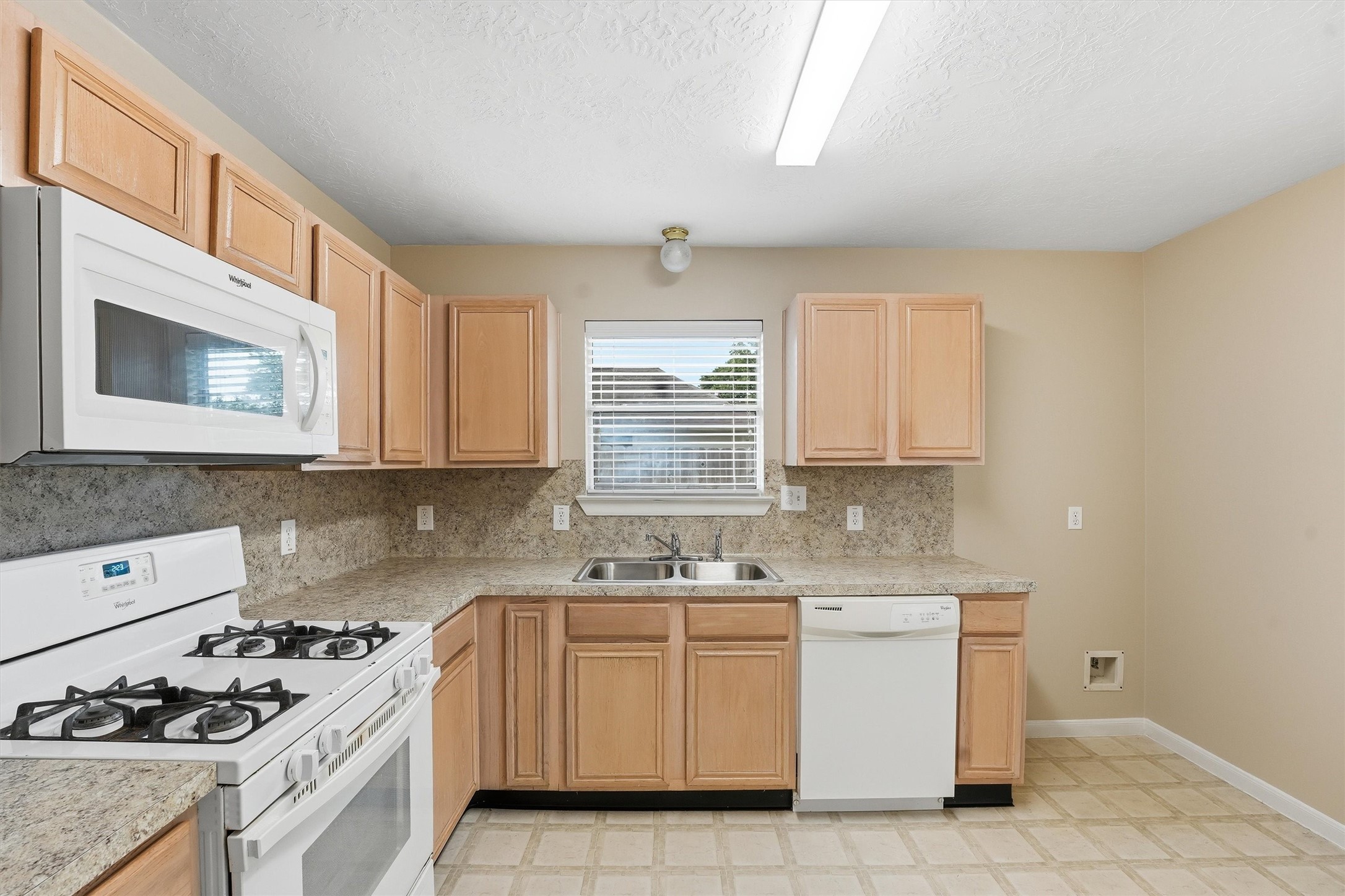 21543 Forest Colony Drive Porter, TX 77365 - Photo 9 of 32 Open concept kitchen, EZ clean floors, white appliances, gas cooking, double pane energy saving windows, microwave over top.