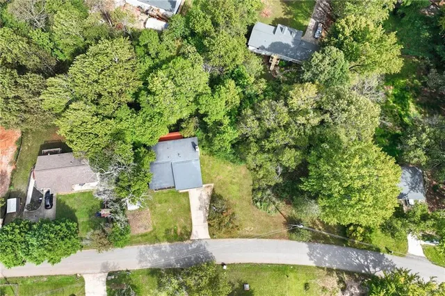 an aerial view of residential house with outdoor space and trees all around
