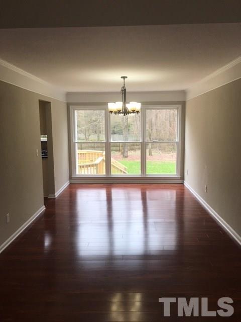 8105 Greywinds Drive Raleigh, NC 27615 - Photo 6 of 18 a view of an empty room with wooden floor and a window