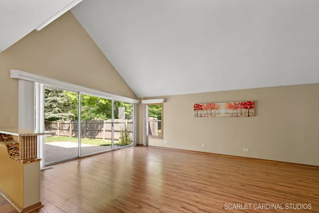 a view of an empty room with wooden floor and a floor to ceiling window