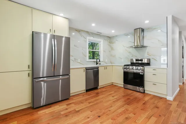 a kitchen with granite countertop a refrigerator and a stove top oven