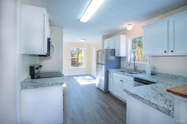 a kitchen with granite countertop cabinets stainless steel appliances a sink and a counter top space