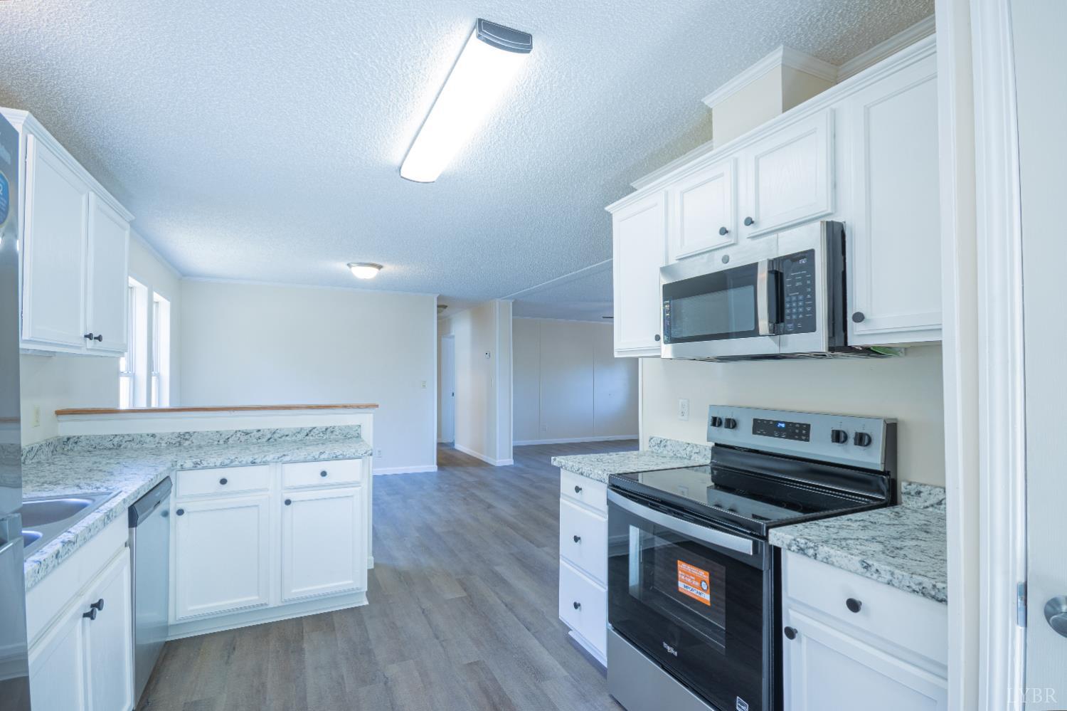 4791 Salem Road Spout Spring, VA 24593 - Photo 5 of 17 a kitchen with granite countertop a stove a microwave a sink and cabinets