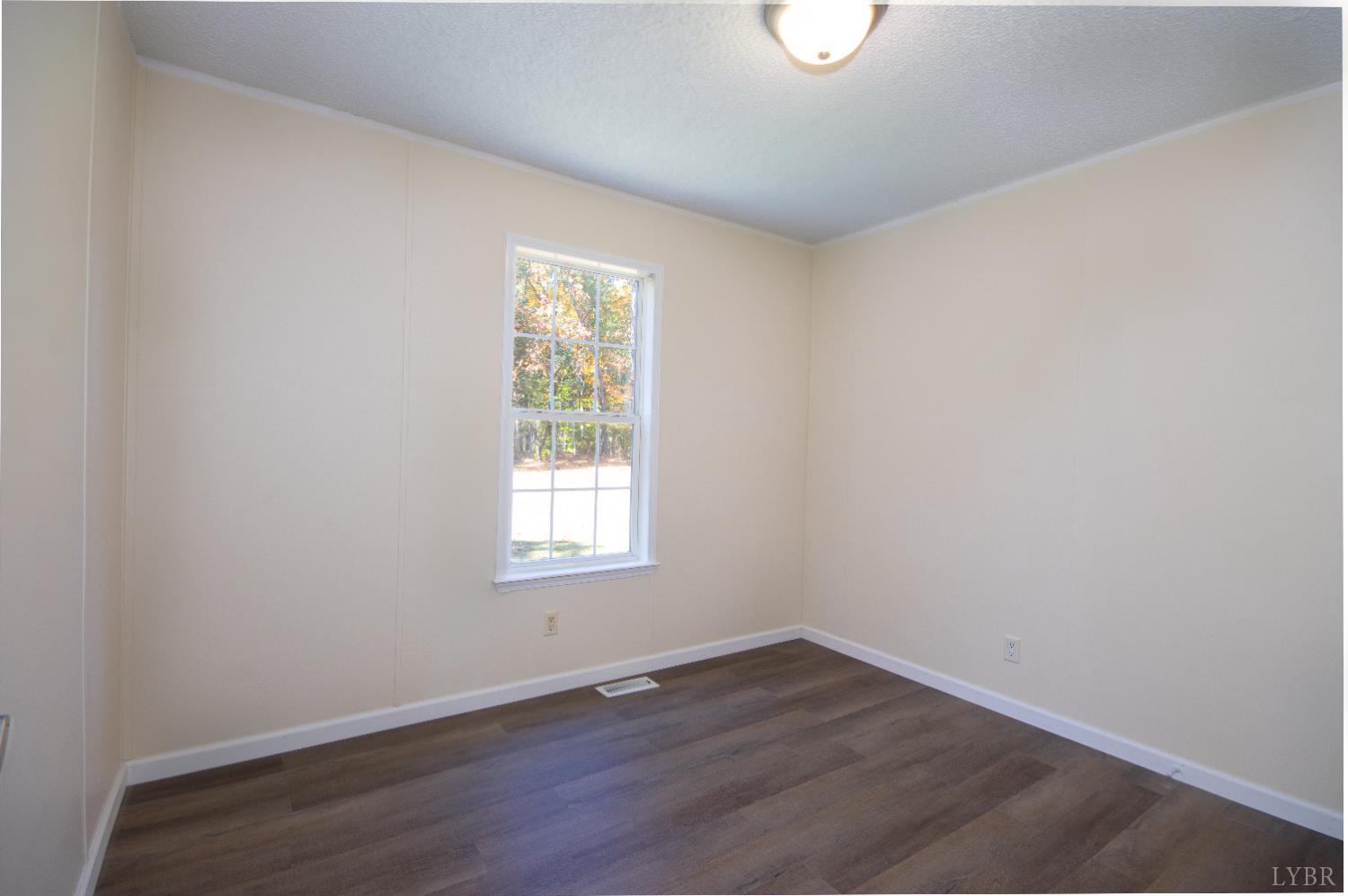 4791 Salem Road Spout Spring, VA 24593 - Photo 7 of 17 an empty room with wooden floor and windows