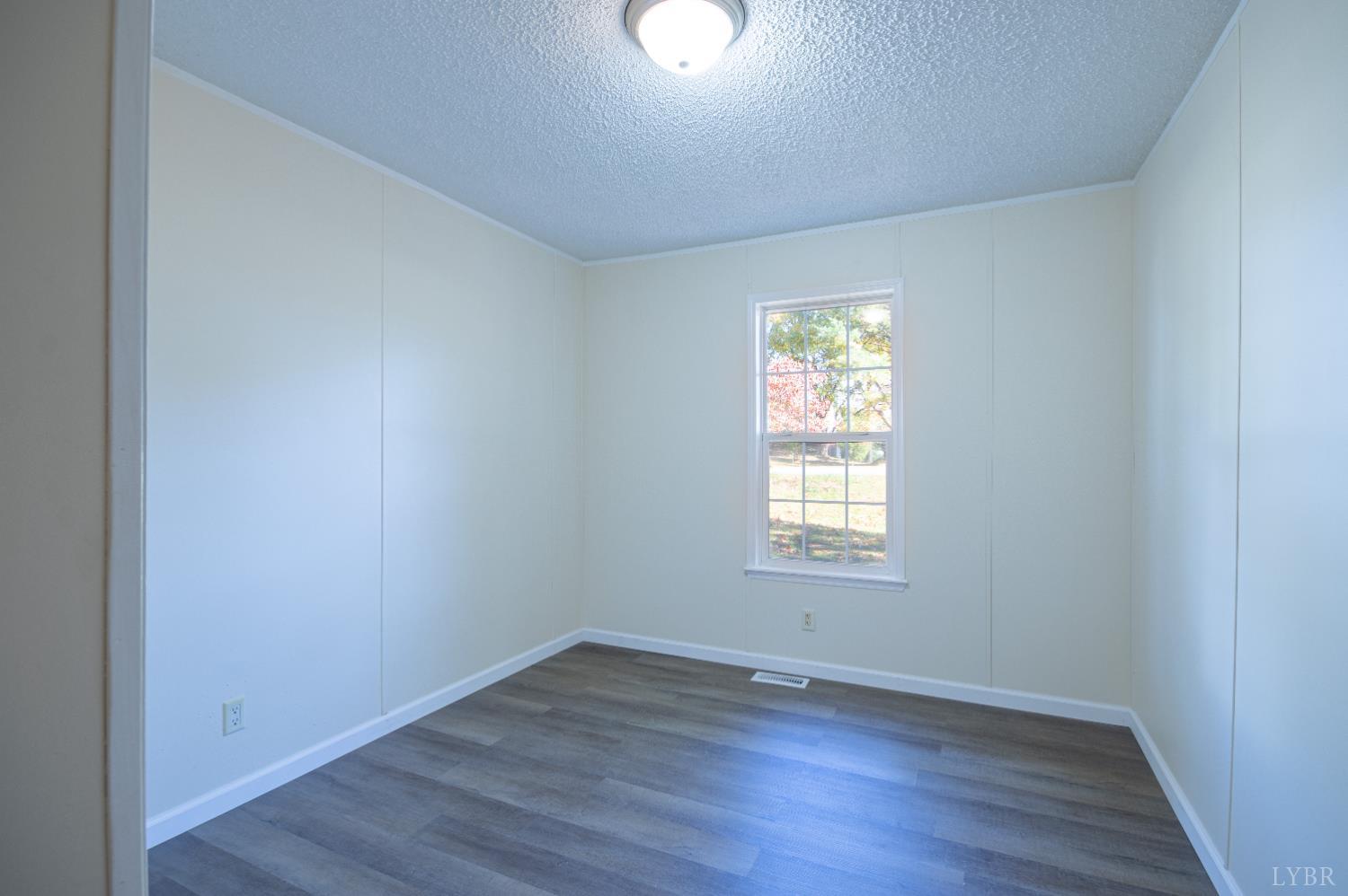 4791 Salem Road Spout Spring, VA 24593 - Photo 9 of 17 an empty room with wooden floor and window