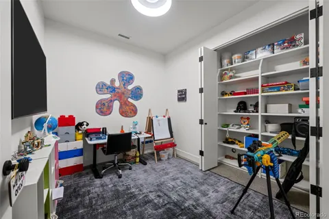 a view of play room with toys and a book shelf
