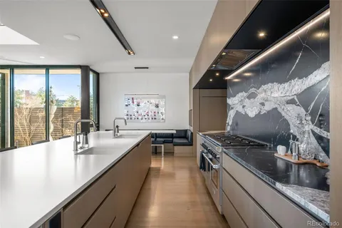 a kitchen with stainless steel appliances a sink dishwasher a stove and a refrigerator with wooden floor