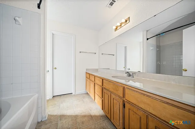 a bathroom with a tub sink and mirror