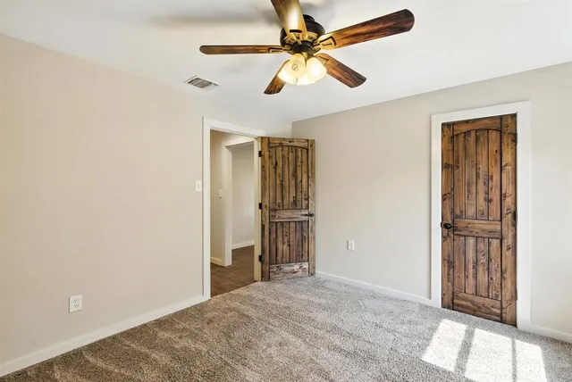 an empty room with closet and windows