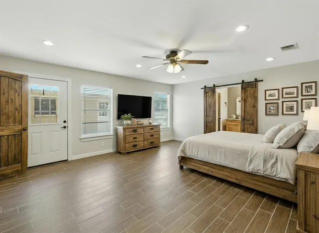 a spacious bedroom with a bed and a flat screen tv