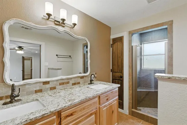 a bathroom with a granite countertop sink and a mirror