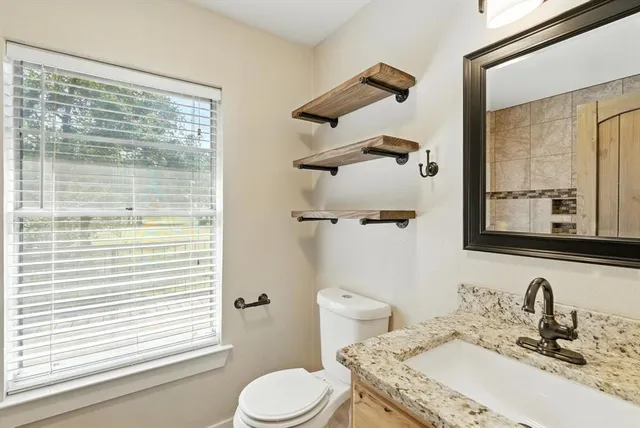 a bathroom with a granite countertop sink toilet and shower
