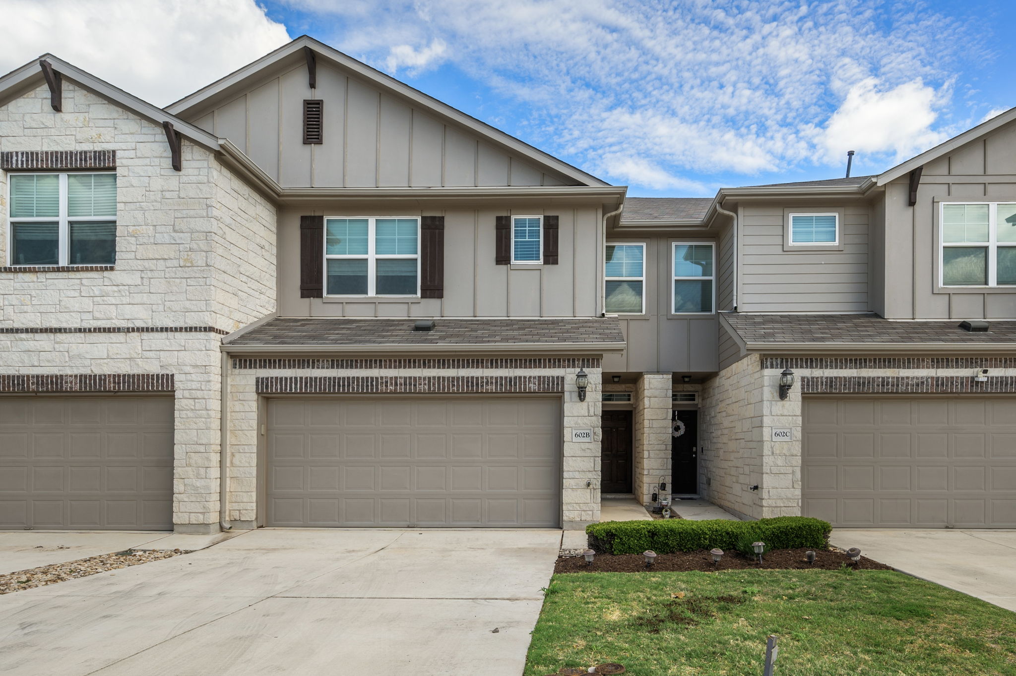 Craftsman-style home featuring board and batten siding, driveway, and a garage