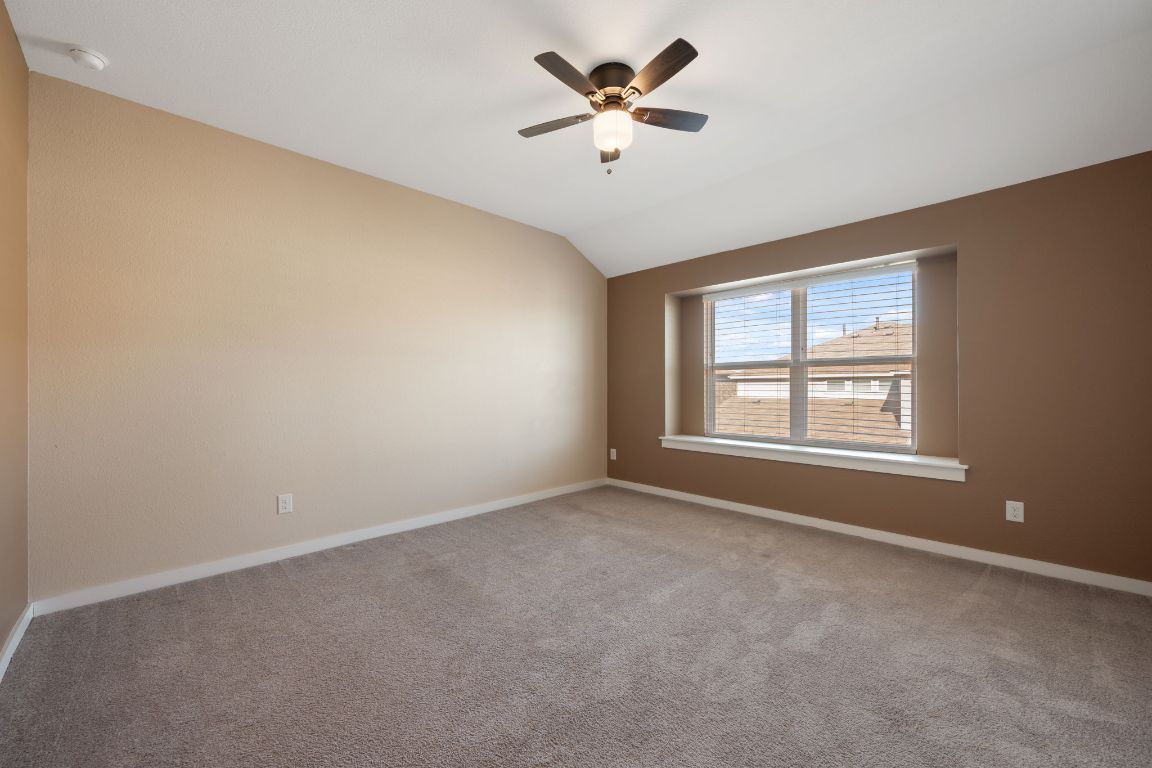 602 Knopper Street, Unit B Pflugerville, TX 78660 - Photo 13 of 26 Carpeted spare room featuring lofted ceiling and ceiling fan