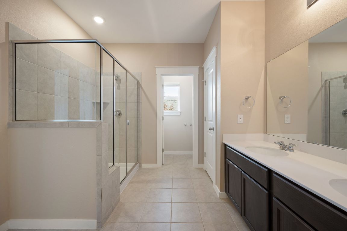 602 Knopper Street, Unit B Pflugerville, TX 78660 - Photo 16 of 26 Full bath with double vanity, a shower stall, light tile patterned floors, and recessed lighting