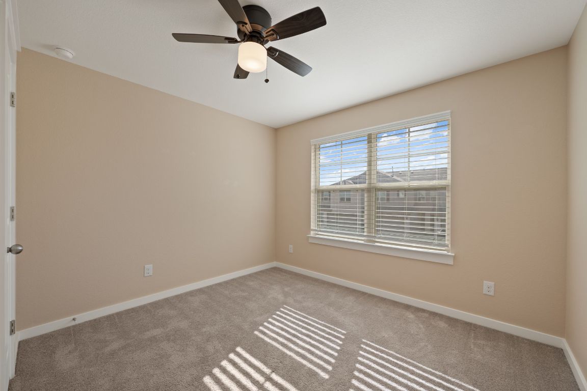 602 Knopper Street, Unit B Pflugerville, TX 78660 - Photo 21 of 26 Carpeted spare room featuring baseboards and ceiling fan