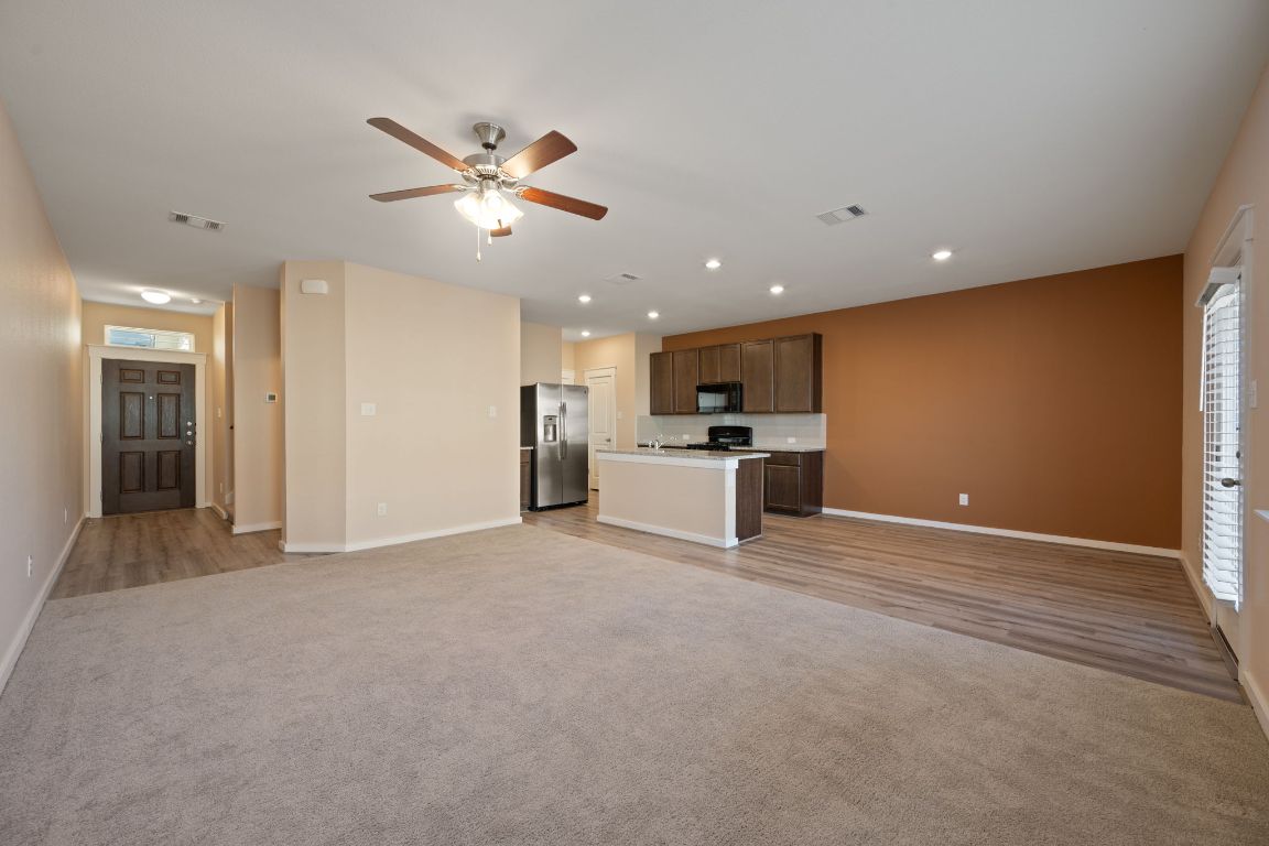 602 Knopper Street, Unit B Pflugerville, TX 78660 - Photo 3 of 26 Unfurnished living room featuring light carpet, ceiling fan, and recessed lighting
