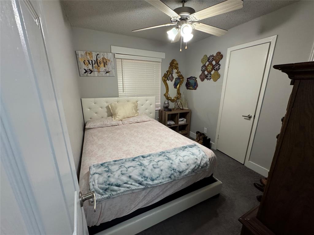 320 Pecan Street Wilmer, TX 75172 - Photo 12 of 25 Bedroom with a textured ceiling, ceiling fan, and dark colored carpet